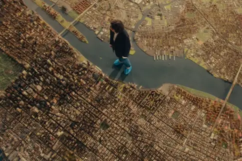 Fran Lebowitz standing on the Panorama of the City of New York in the Queens Museum